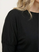 woman wearing cozy chic two-piece sweatsuit set with long-sleeve top and high-waisted pants with pockets