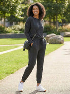 woman wearing cozy chic two-piece sweatsuit set with long-sleeve top and high-waisted pants with pockets