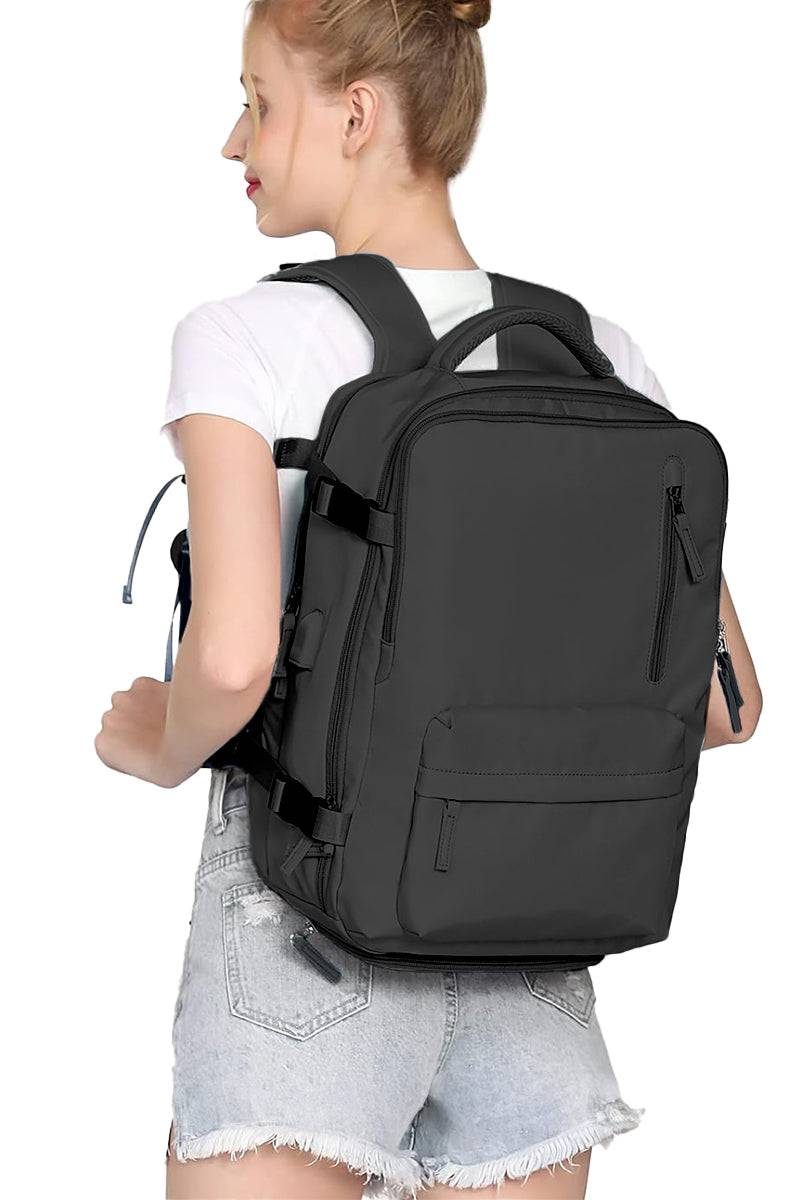 Chic Wanderlust Waterproof Backpack black ergonomic travel bag with multiple compartments worn by woman in white t-shirt and denim shorts