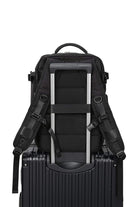 Chic Wanderlust Waterproof Backpack attached to suitcase handle, black ergonomic travel bag with padded straps and durable fabric