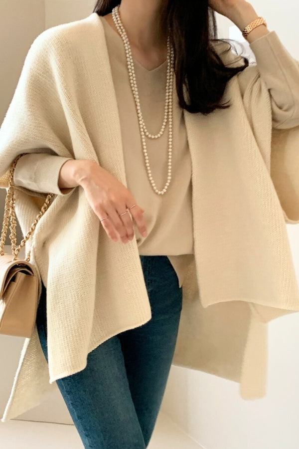 Relaxed flowy open front knitwear cardigan in beige with a loose, draped fit, styled with jeans and a pearl necklace