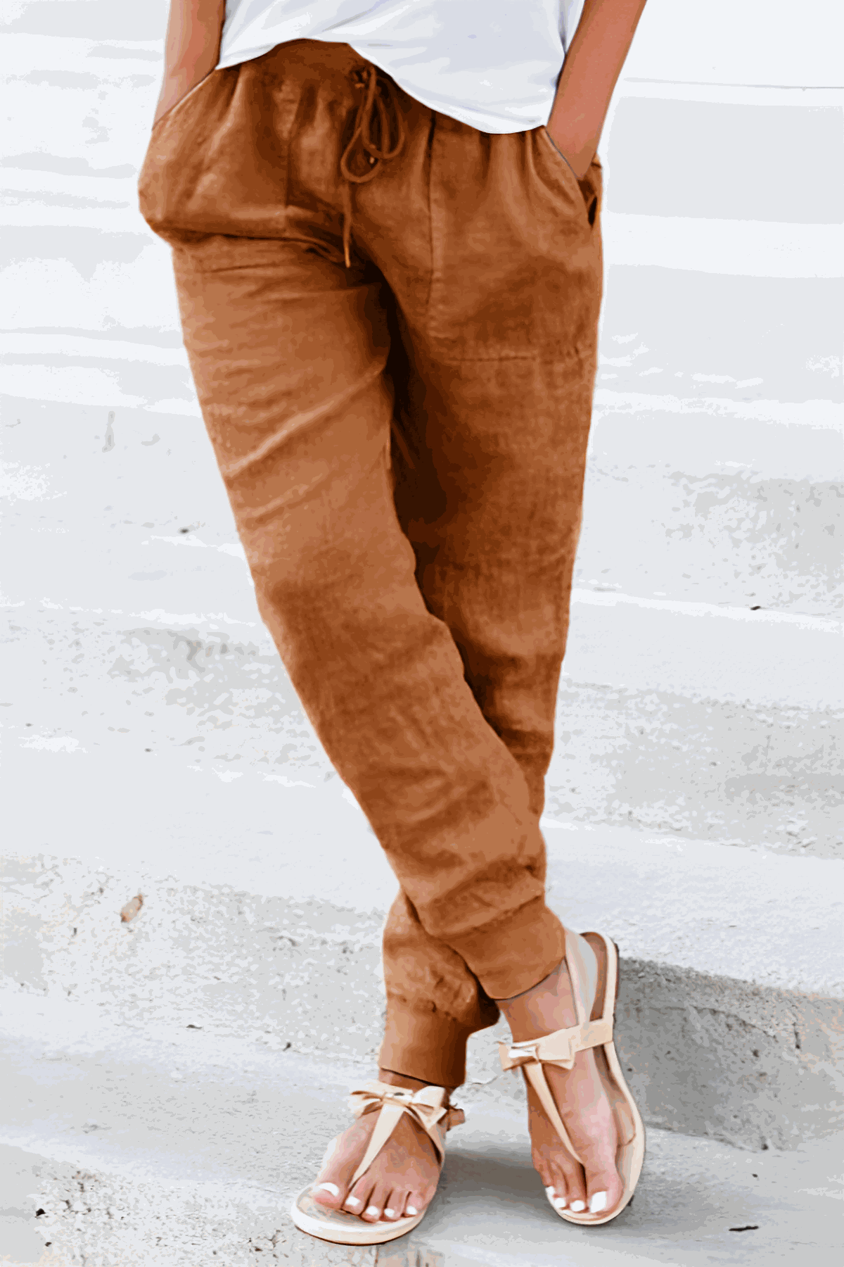 Woman wearing relaxed chic elastic ankles pants in neutral tones, styled casually with white sneakers
