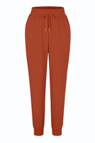 Woman wearing relaxed chic elastic ankles pants standing against a white wall