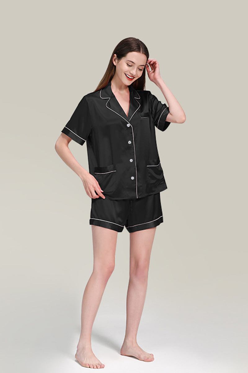 Woman wearing black Mulberry silk buttoned short sleepwear set with white piping