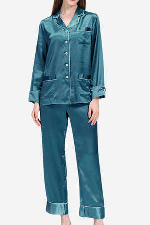Woman wearing teal long sleeve silk pajamas with button-up top and full-length pants
