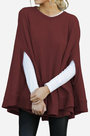 Elegant Poncho Pullover in burgundy, lightweight and soft polyester fabric, loose fit, styled over white long-sleeve top