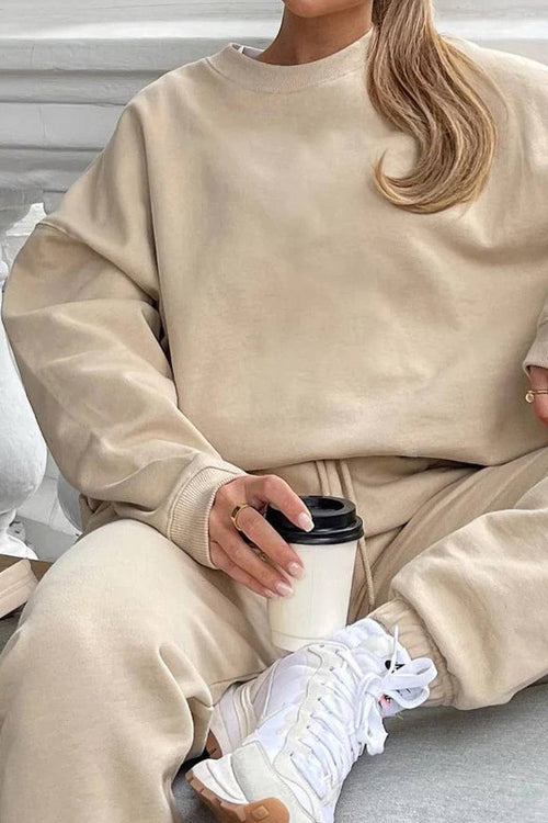 Beige Classic Comfort Athleisure set with relaxed fit sweatshirt and matching pants paired with white sneakers and coffee cup