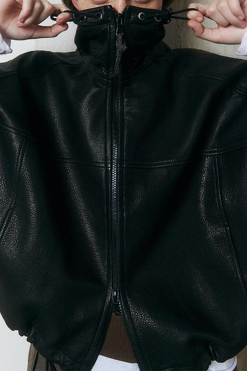 Close-up of black genuine sheepskin leather jacket with high collar and zipper detail