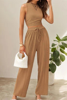 Woman wearing tan Stroll & Hangout Ribbed Knit sleeveless top and wide-leg pants two-piece set holding white handbag