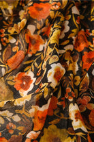 Twilight Blooms Scarf with warm amber, rust, and cream floral print on lightweight polyester fabric