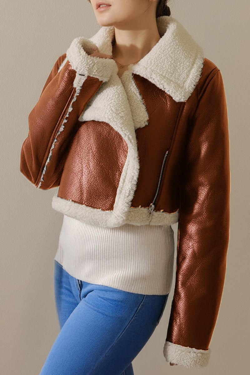 Cropped faux leather jacket with soft cream sherpa lining and trim, warm and wind-resistant, styled on a woman with jeans and a white top
