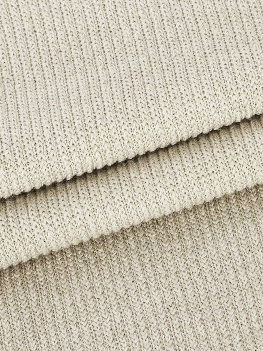 Close-up of soft beige waffle-knit two-piece fabric texture with ribbed pattern