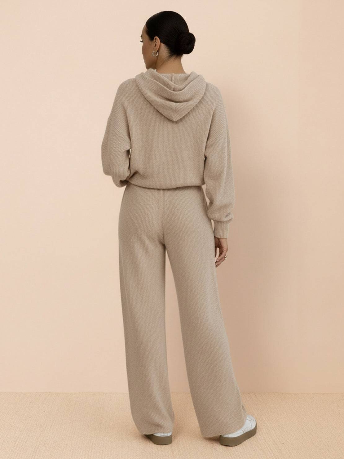 Woman wearing beige waffle-knit two-piece set with hoodie and wide-leg pants from back view