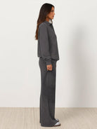 Woman wearing a wrinkle-free polo set with quarter-button top and high-waisted pants in a casual, structured fit