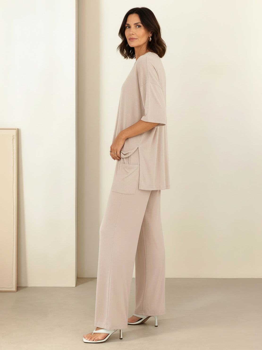 Woman wearing oversized long-line loungewear set with pullover and wide-leg pants in soft knit fabric