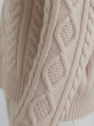 Oversized cable-knit crewneck sweater with dropped shoulders and ribbed trim