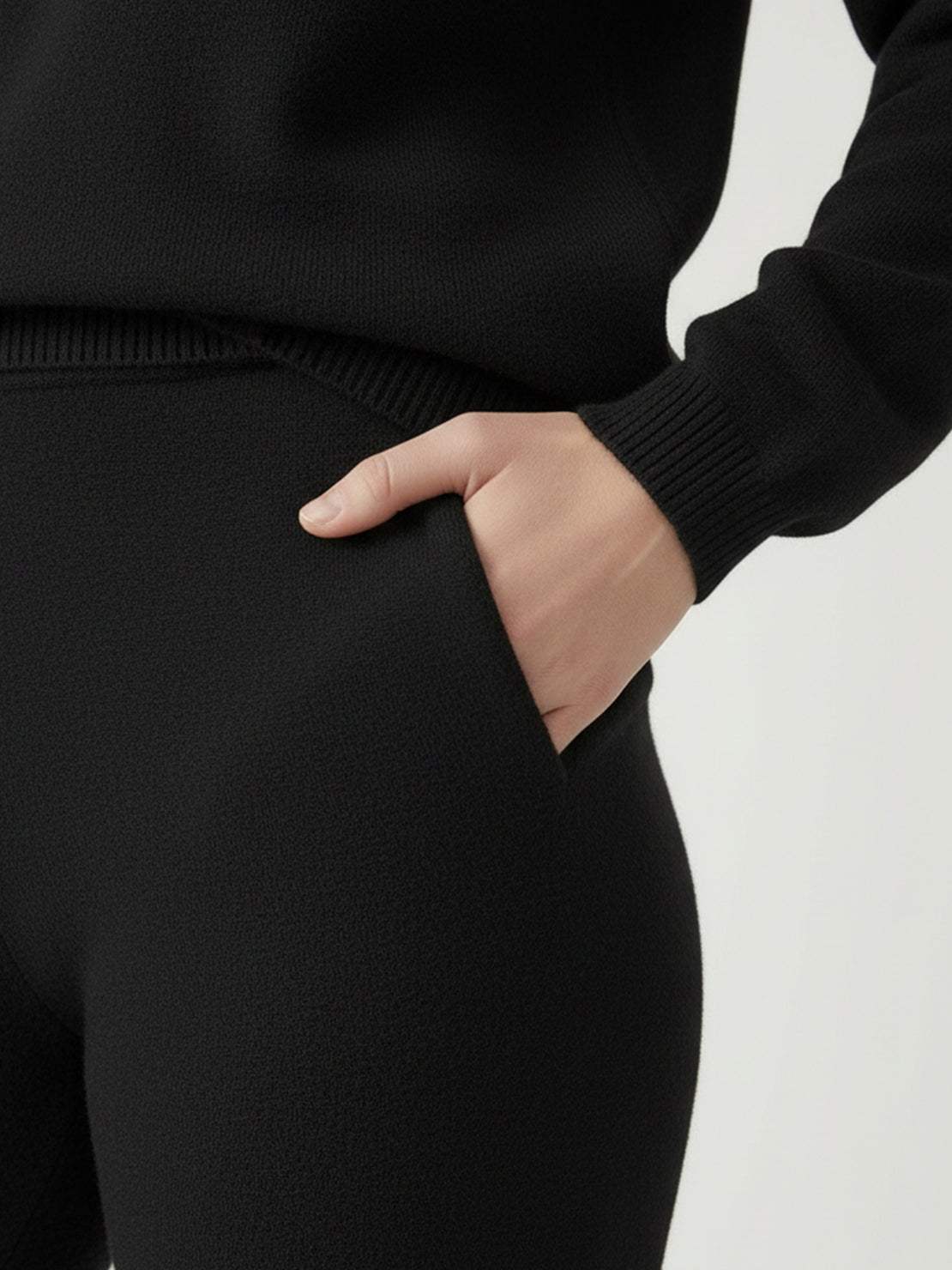 Woman wearing oversized polo knit loungewear set with soft collar and straight-leg pants in neutral color