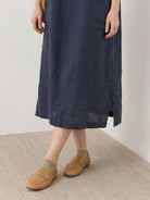 Woman wearing a 100% linen pocket midi dress with short sleeves and side slits