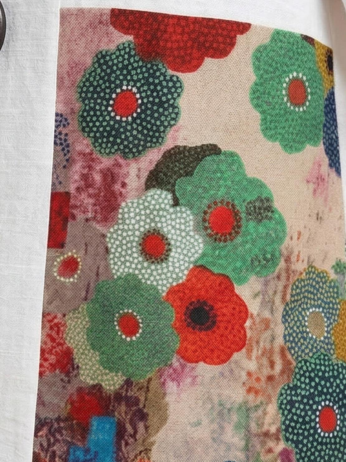 Oversized cotton linen floral shirt with round neckline and elbow-length sleeves featuring bold botanical panel and printed cuff trim