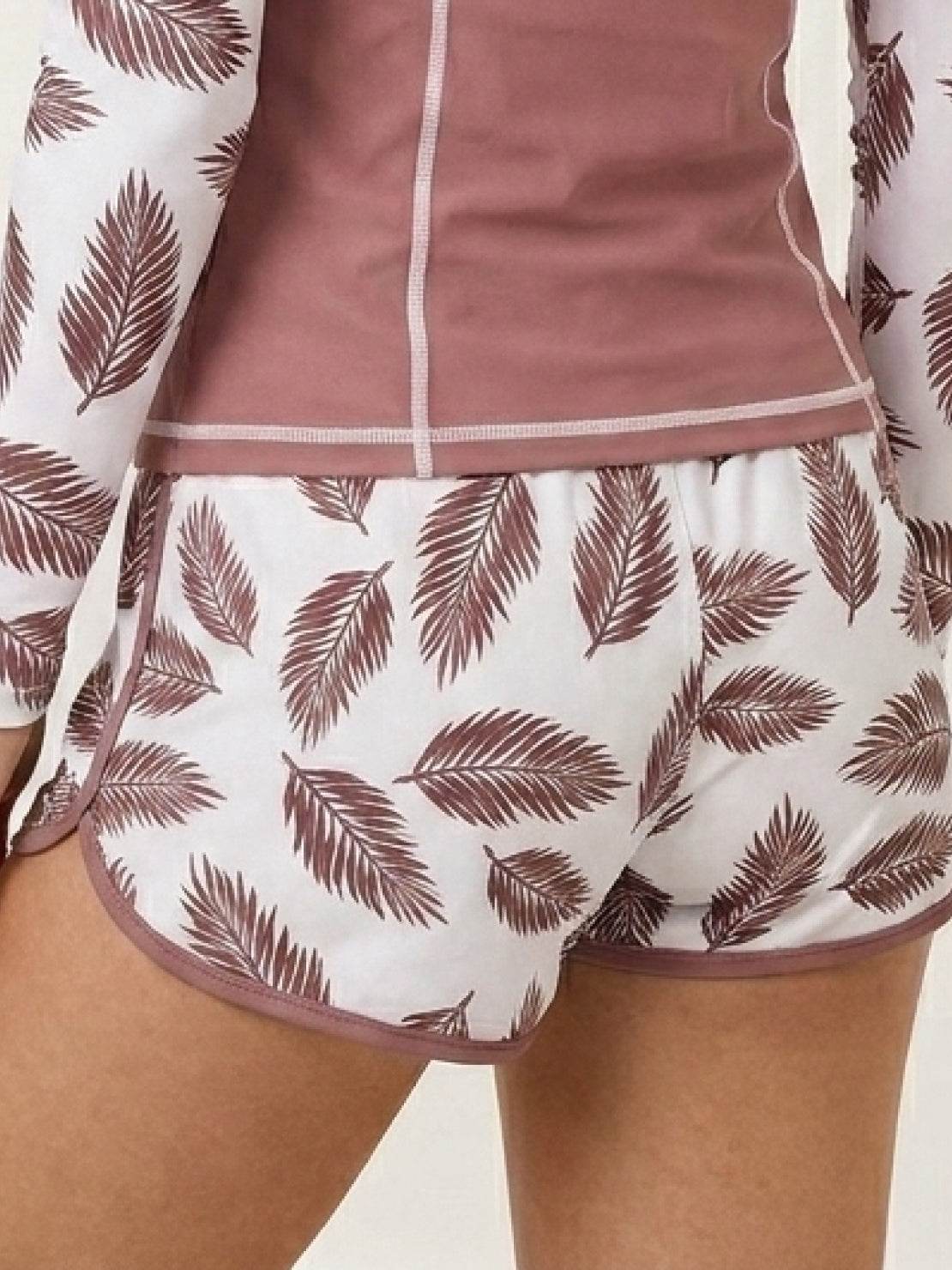 Long-sleeve UV rash guard set with tropical print sleeves and matching swim shorts for sun protection and sporty beachwear