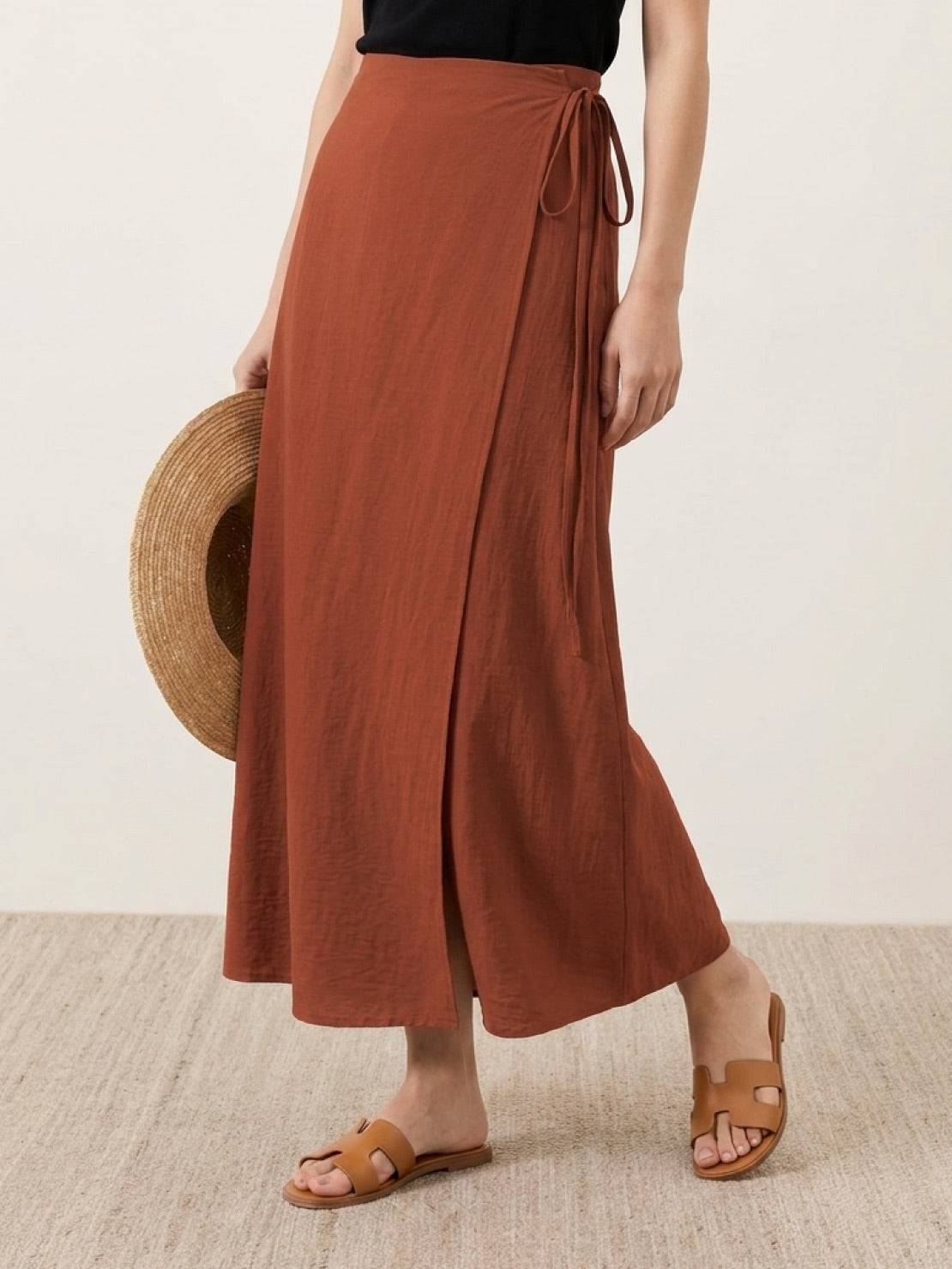Woman wearing asymmetrical wrap maxi skirt with side tie and flowing asymmetric hem