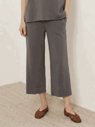 Woman wearing a cotton-blend capelet top with batwing sleeves and wide-leg pants lounge set in neutral color
