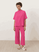 Woman wearing cotton-blend capelet top with batwing sleeves and wide-leg cropped pants lounge set in chocolate brown