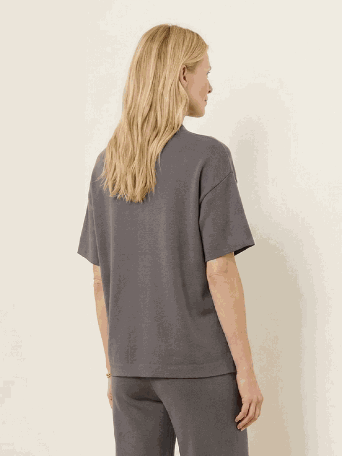 Woman wearing cotton-blend capelet top with batwing sleeves and wide-leg cropped pants lounge set in soft fabric