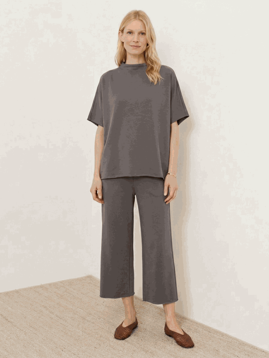 Woman wearing a cotton-blend capelet top with batwing sleeves and cropped wide-leg pants in a lounge set