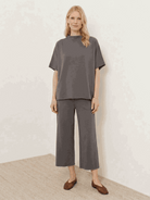 Woman wearing a cotton-blend capelet top with batwing sleeves and cropped wide-leg pants in a lounge set