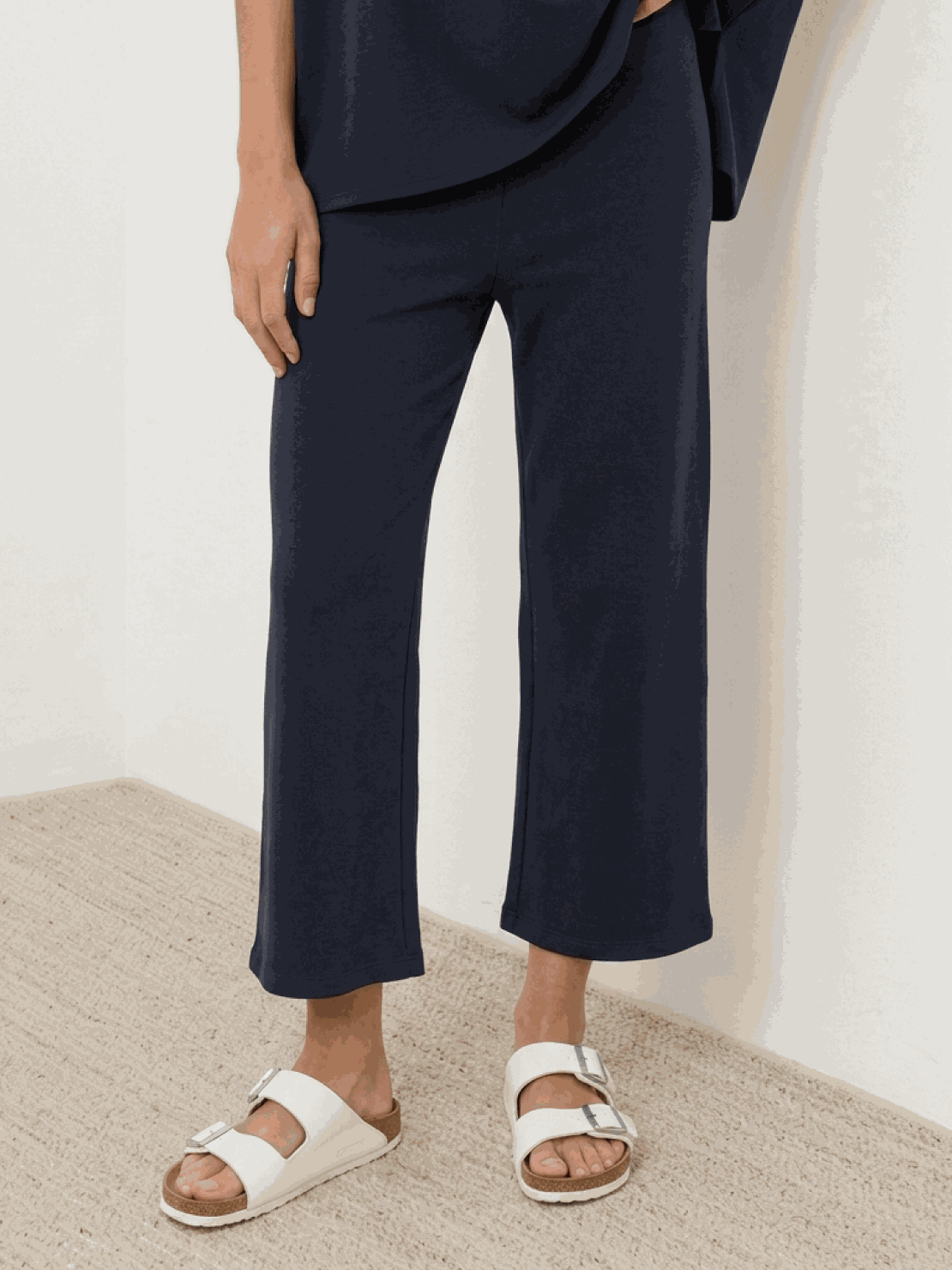 Woman wearing chocolate brown cotton-blend capelet top with batwing sleeves and wide-leg pants lounge set