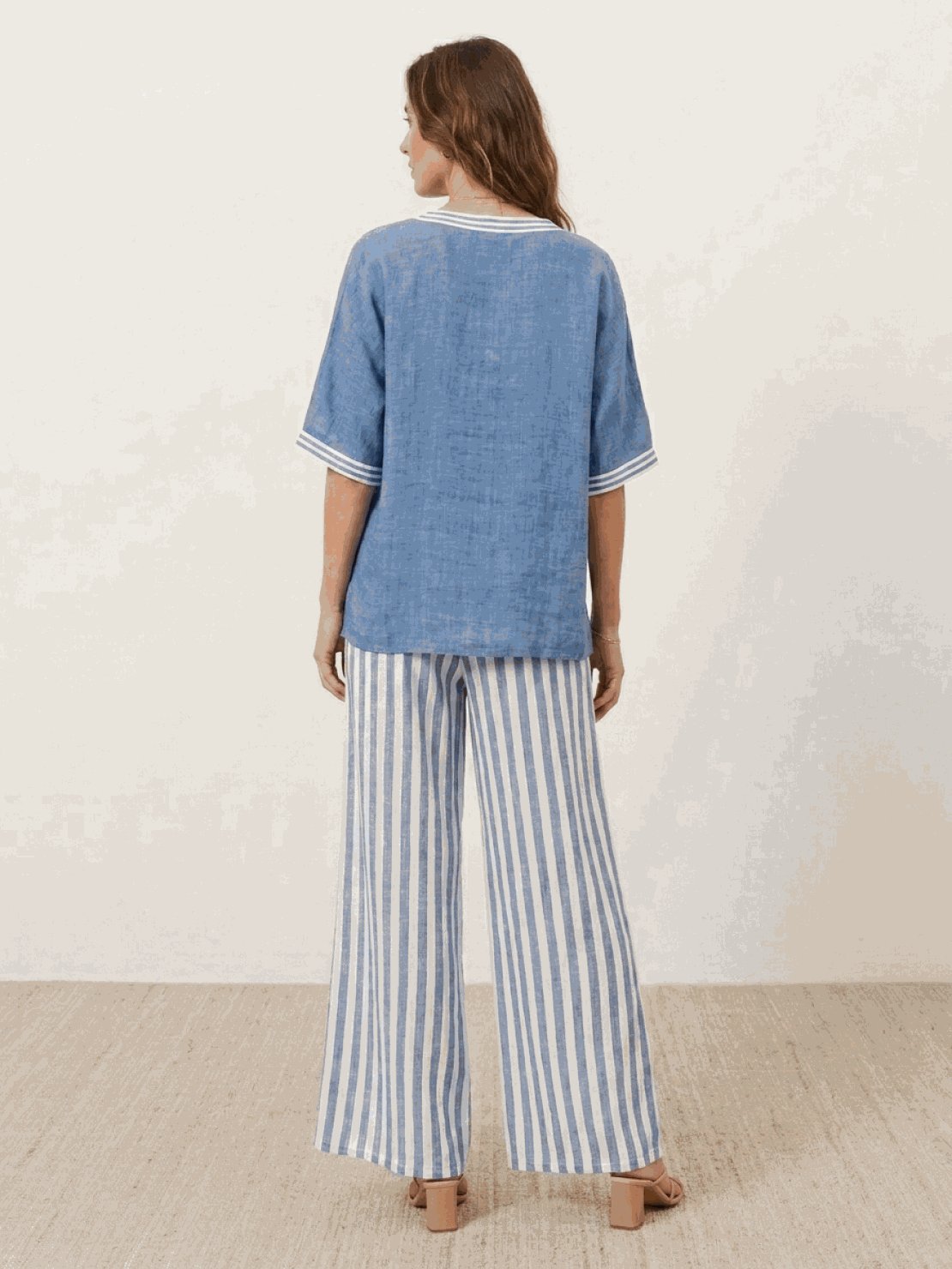 Woman wearing a striped wide-leg co-ord set with oversized top and palazzo pants featuring contrast stripe trim and elastic waistband