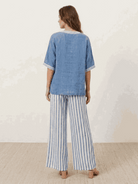 Woman wearing a striped wide-leg co-ord set with oversized top and palazzo pants featuring contrast stripe trim and elastic waistband