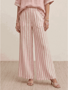 Woman wearing striped wide-leg co-ord set with oversized top and palazzo pants in multiple colors