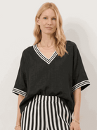 Woman wearing striped wide-leg co-ord set with oversized top and palazzo pants with contrast stripe trim and side pockets