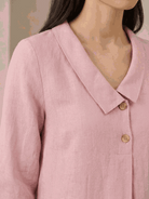 woman wearing navy linen-look midi dress with blazer neckline and button detail standing outdoors
