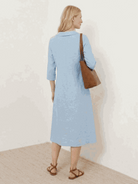 Woman wearing relaxed fit linen-look midi dress with blazer neckline and button detail