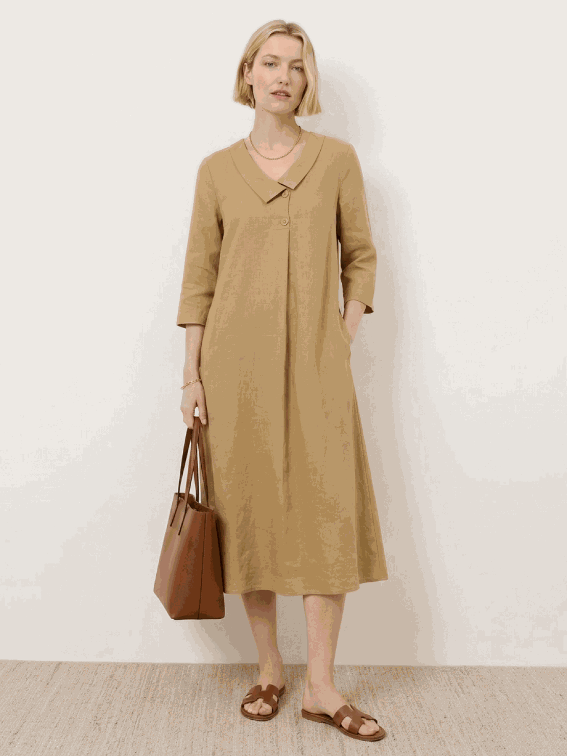 Woman wearing navy linen-look midi dress with relaxed fit and blazer-inspired neckline outdoors