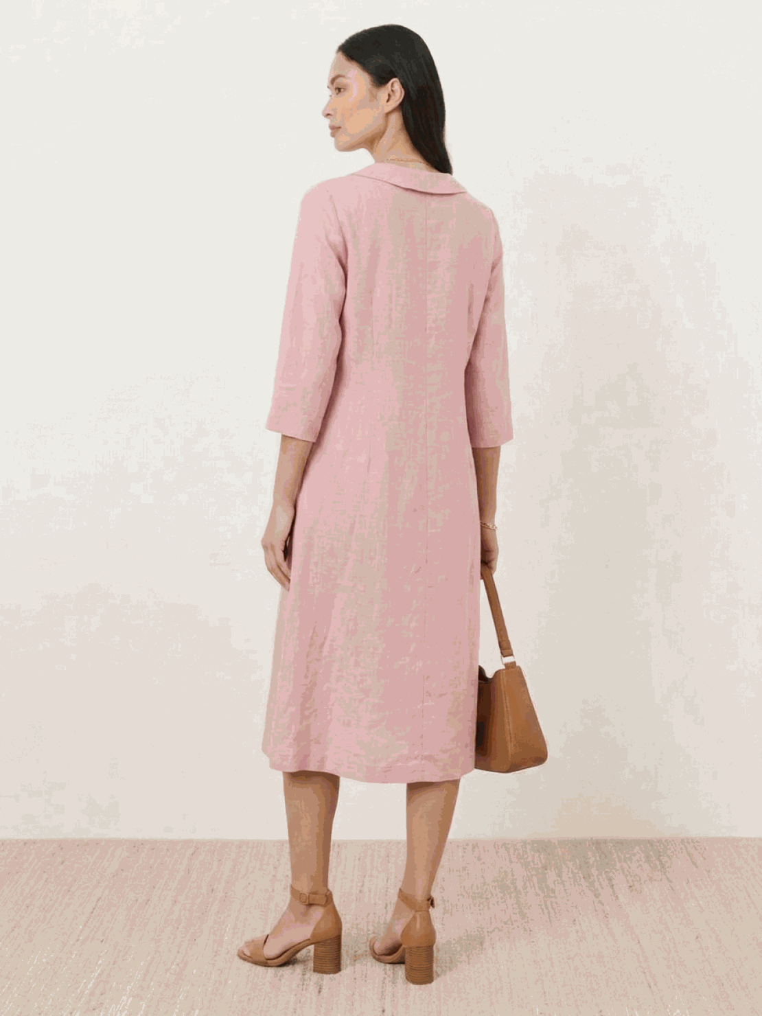 Woman wearing navy linen-look midi dress with V-neckline and button detail, relaxed fit and side pockets