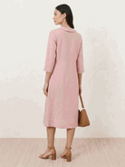 Woman wearing navy linen-look midi dress with V-neckline and button detail, relaxed fit and side pockets