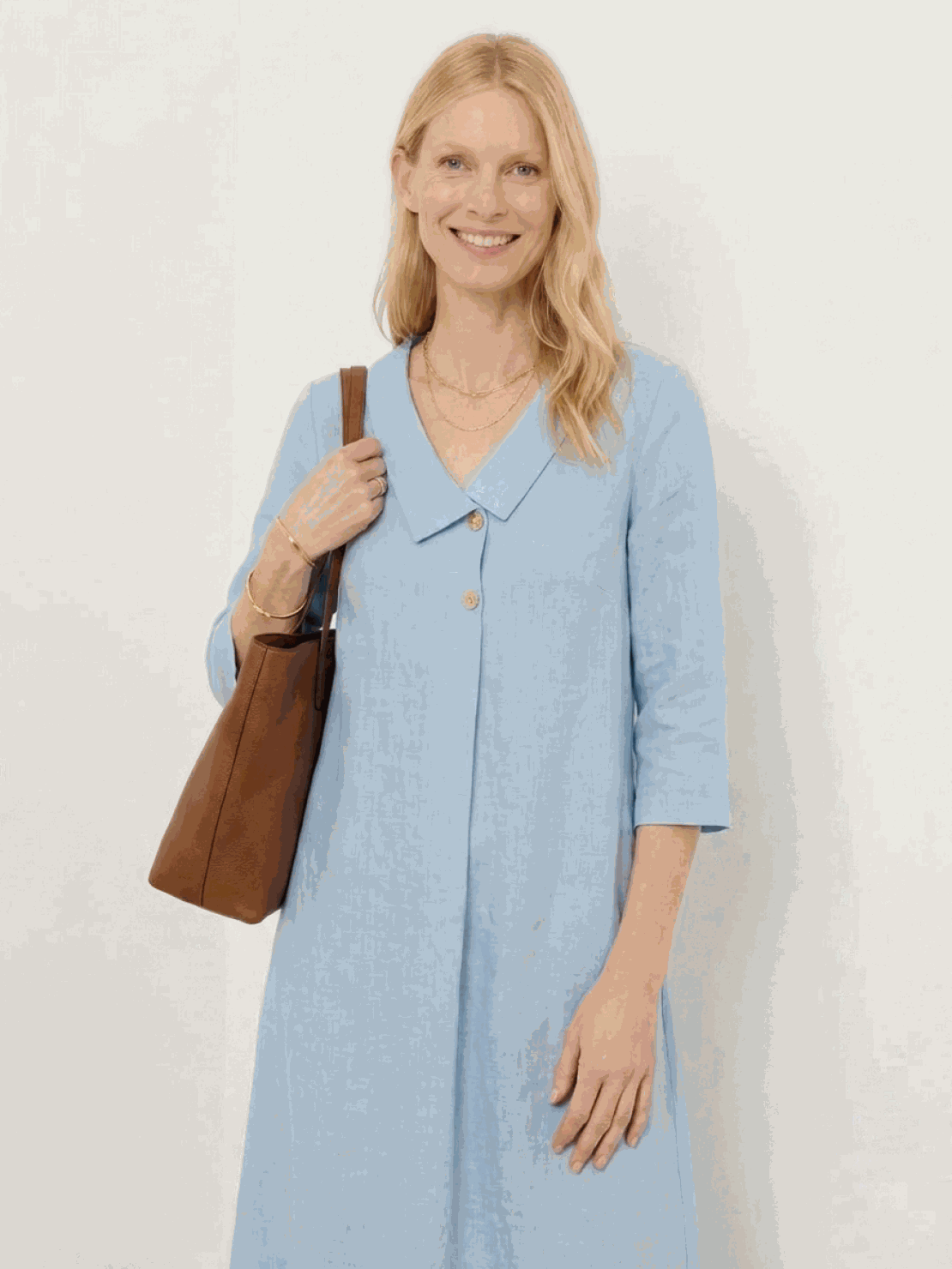 Woman wearing navy linen-look midi dress with blazer neckline and button detail standing outdoors