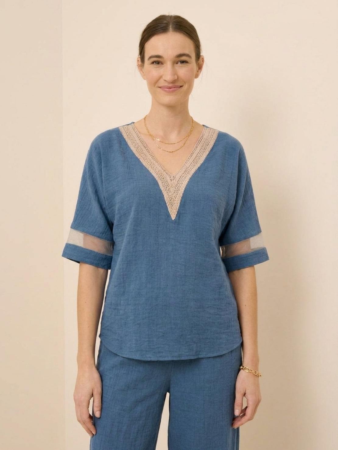 Mature woman wearing a lightweight linen top with V-neck and three-button detail in relaxed boxy shape