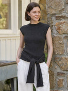 Beige knit vest with attached scarf showcasing sleeveless, ribbed texture, and multi-way styling options