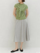 Beige knit vest with attached scarf in fine ribbed knit, sleeveless design, and mock neckline.