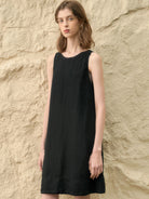 woman wearing sleeveless linen lyocell blend midi shift dress with hand-stitched neckline detail