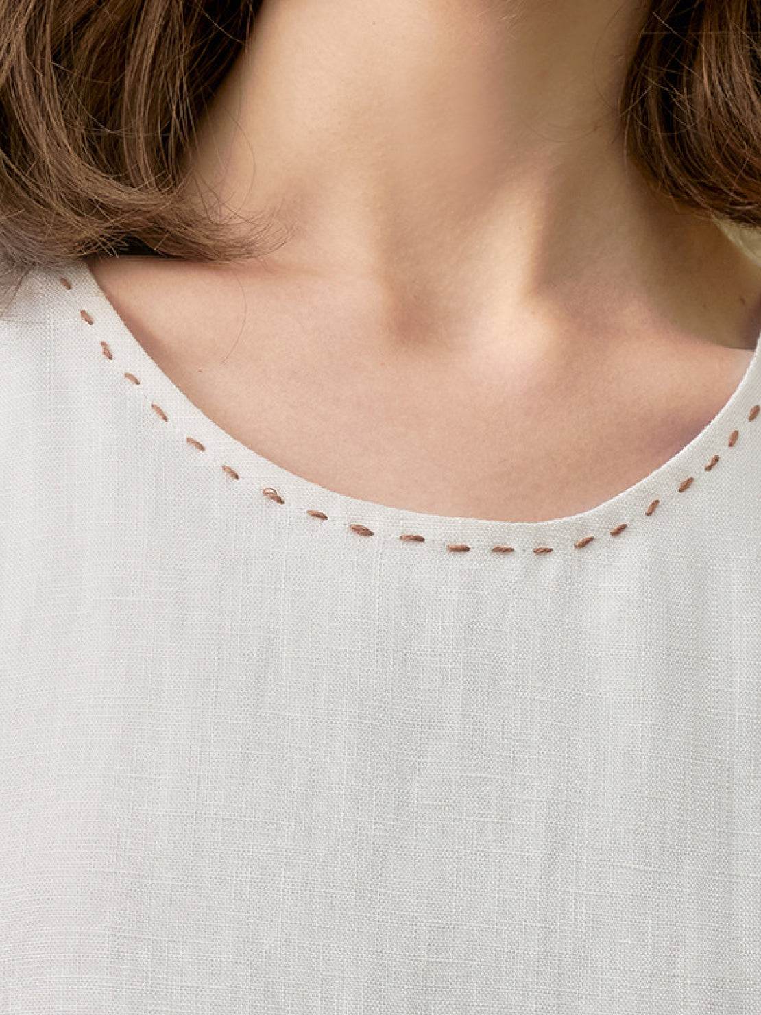 White sleeveless linen lyocell blend dress with relaxed A-line silhouette and hand-stitched neckline detail