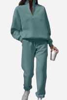 Woman wearing a soft cotton-blended two-piece tracksuit with a high collar and deep zipper in a relaxed, matching monochrome style