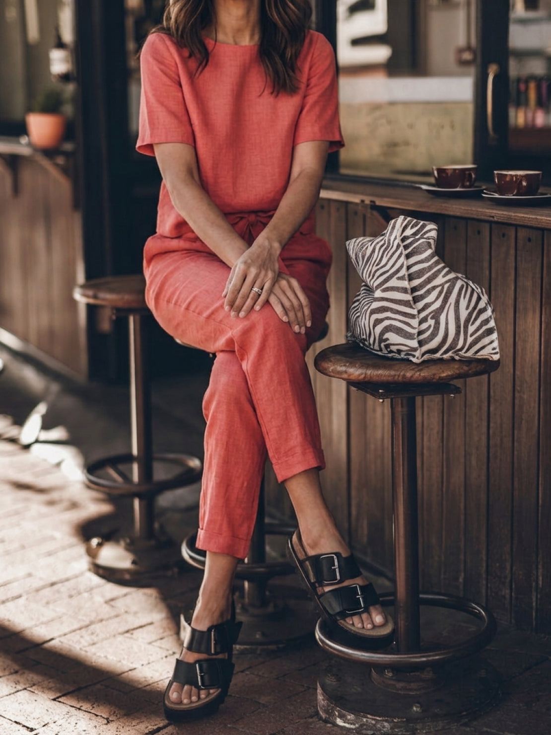 Woman wearing a breathable cotton linen set with relaxed short-sleeve top and straight-leg pants in monochrome tones