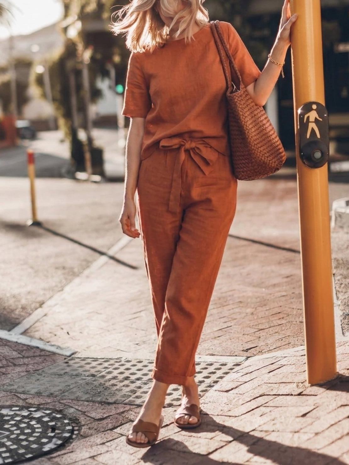 Model wearing a breathable cotton linen set with relaxed short-sleeve top and straight-leg pants in a monochrome palette
