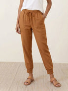 Woman wearing relaxed chic elastic ankles pants posing outdoors on stairs